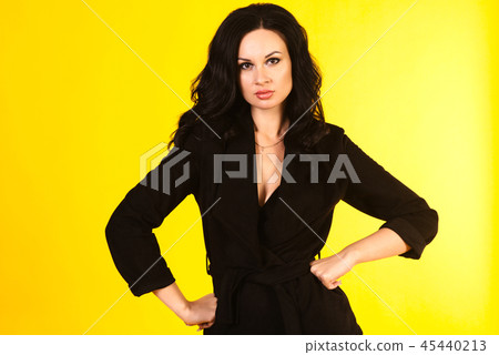 Business woman in a black suit, isolated on yellow 45440213