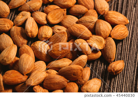 Apricot kernels are scattered on the wooden 45440830