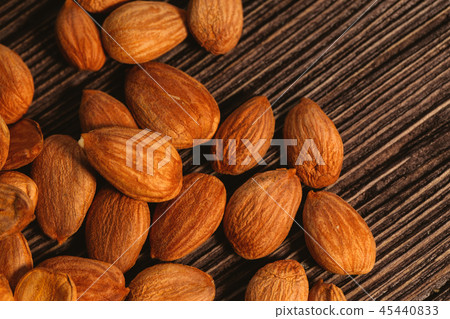 Apricot kernels are scattered on the wooden Apricot kernels are scattered on the wooden 45440833