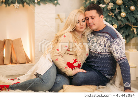 Happy family sits by the fireplase in their house. Christmas mood Happy family sits by the fireplase in their house. Christmas mood 45442084