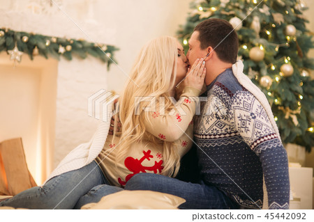 Happy family sits by the fireplase in their house. Christmas mood Happy family sits by the fireplase in their house. Christmas mood 45442092