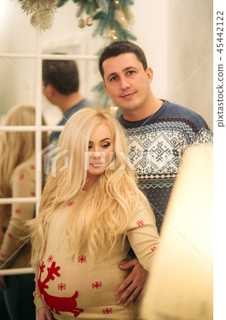 Happy couple stand near the mirror in Christmas time. Holliday spirit 45442122