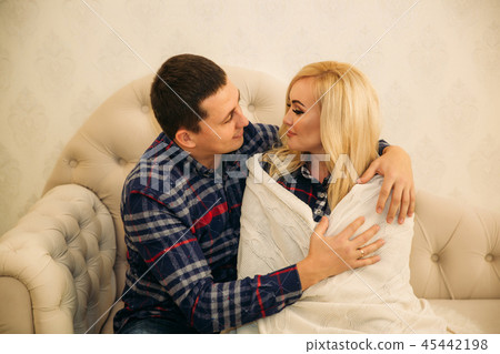 Happy couple in holiday spirit showing affection for one another. Dressed in plaid clothes. Gentle 45442198