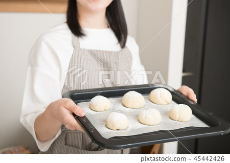 Bread making hand of young woman holding a baking sheet 45442426