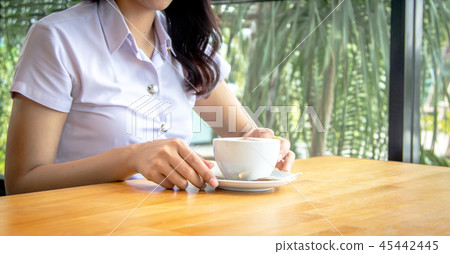 hand hold spoon to mix hot coffee foam on cup hand hold spoon to mix hot coffee foam on cup 45442445