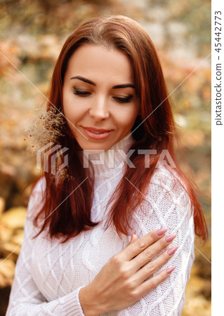 woman in dress and hat on background of autumn foliage 45442773