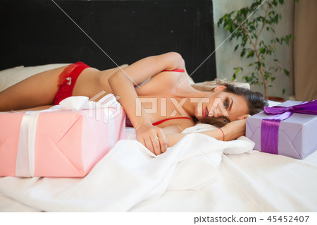 Portrait of beautiful woman in underwear gift on a white background Portrait of beautiful woman in underwear gift on a white background 45452407