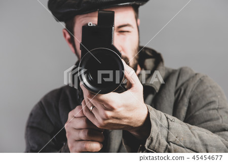 Cameraman with a retro camera in his hands, studio 45454677