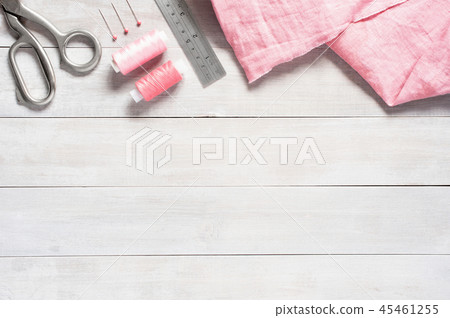Sewing items and pink linen fabric on the table 45461255
