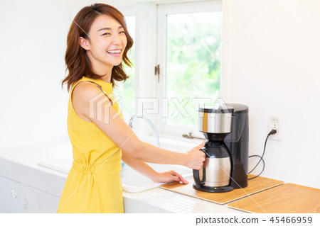 A woman who puts coffee in the kitchen A woman who puts coffee in the kitchen 45466959