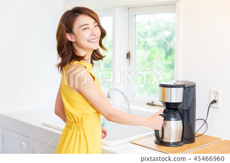 A woman who puts coffee in the kitchen A woman who puts coffee in the kitchen 45466960