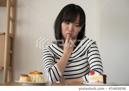 把蛋糕放的年輕日本婦女在飲食上 45468696
