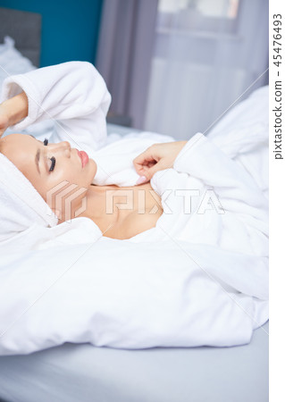 A woman in a bathrobe and a towel on her head A woman in a bathrobe and a towel on her head 45476493