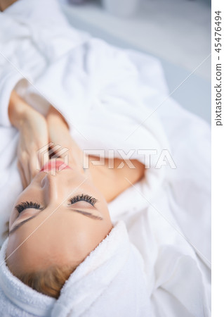 A woman in a bathrobe and a towel on her head A woman in a bathrobe and a towel on her head 45476494