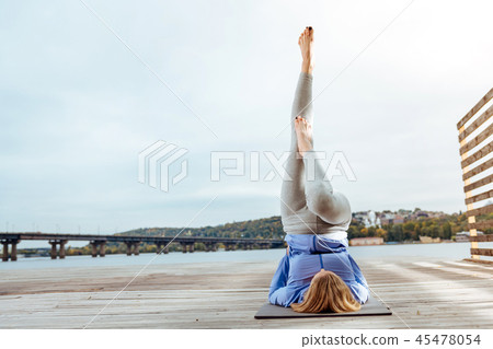 Young woman easily performing Supported Shoulderstand outdoor Young woman easily performing Supported Shoulderstand outdoor 45478054