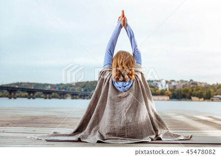 Woman covered with the brown plaid practising meditation 45478082