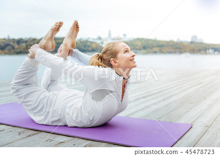 Woman practising Bow Pose for improving her health Woman practising Bow Pose for improving her health 45478723