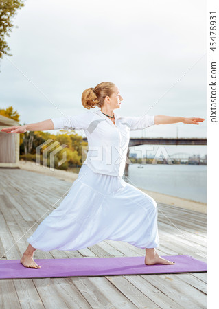 Young woman practising yoga near the water Young woman practising yoga near the water 45478931