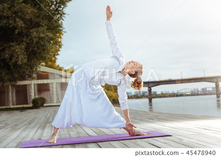 Woman standing in the triangle pose while doing morning yoga Woman standing in the triangle pose while doing morning yoga 45478940