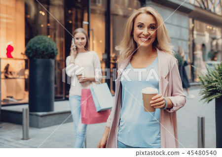 Charming lady standing on the street while her daughter talking on cellphone 45480540