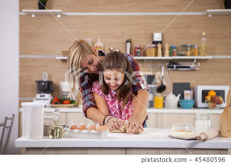 Portrait of excited mom and daughter having fun while cooking 45480596