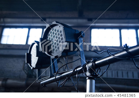 Theater spotlights on black industrial room with windows. 45481365