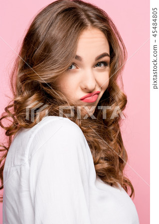 Suspiciont. Doubtful pensive woman with thoughtful expression making choice against pink background Suspiciont. Doubtful pensive woman with thoughtful expression making choice against pink background 45484805
