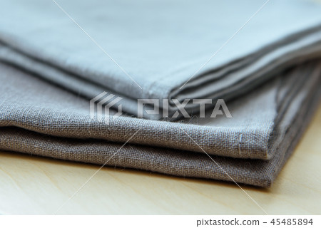 Manufactures industrial textile - grey towels pile isolated on wooden background. 45485894