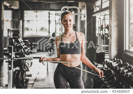 woman measures the waist in fitness gym woman measures the waist in fitness gym 45488607