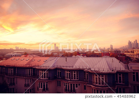Clouds of beautiful color against the roofs of houses. Sunset pink red orange. Clouds of beautiful color against the roofs of houses. Sunset pink red orange. 45488962