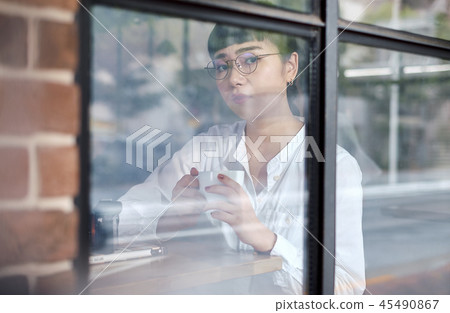 A woman relaxing at a cafe 45490867