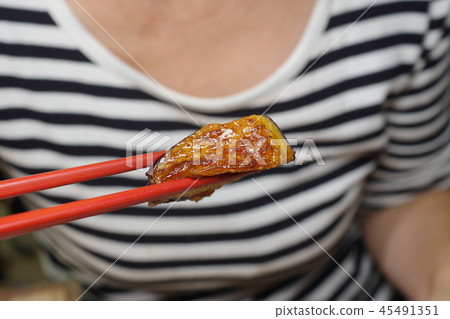 Woman eating fried eggplant 45491351
