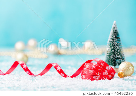 Christmas, New Year blue background with red ribbon and green eve ornaments. Copy space. Christmas, New Year blue background with red ribbon and green eve ornaments. Copy space. 45492280