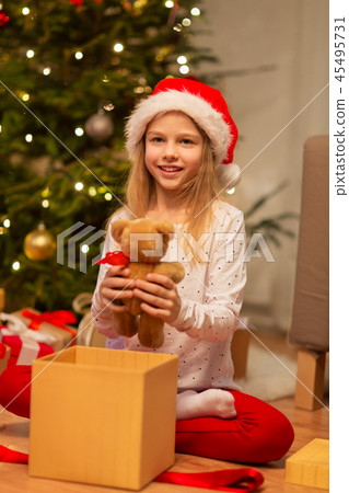 smiling girl in santa hat with christmas gift smiling girl in santa hat with christmas gift 45495731
