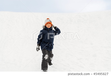 happy boy playing and throwing snowball in winter 45495827