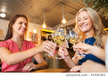 happy women drinking wine at bar or restaurant 45495965