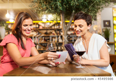 women looking at bill at wine bar or restaurant 45495986