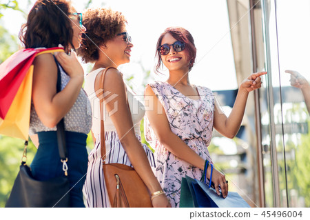 women with shopping bags looking at shop window women with shopping bags looking at shop window 45496004