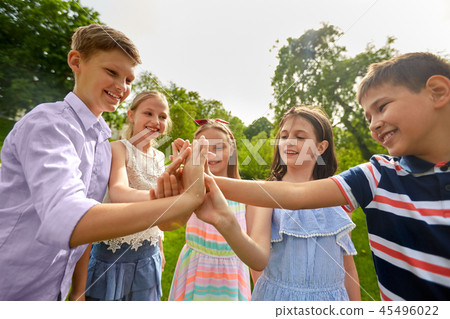 group of happy kids making high five outdoors 45496022