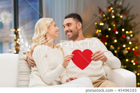 happy couple with red heart at home on christmas 45496183