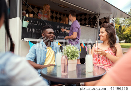 friends with drinks sitting at table at food truck friends with drinks sitting at table at food truck 45496356