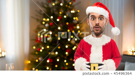 surprised man in santa clothes over christmas tree surprised man in santa clothes over christmas tree 45496364