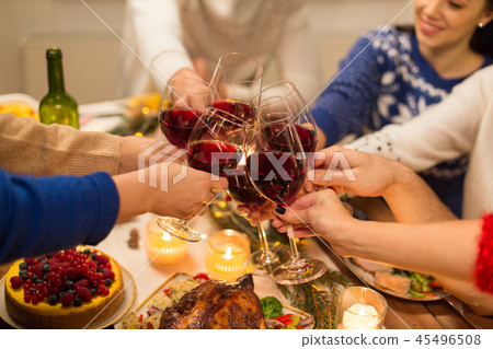 close up of friends with wine celebrate christmas 45496508