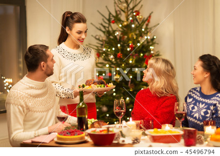 happy friends having christmas dinner at home happy friends having christmas dinner at home 45496794