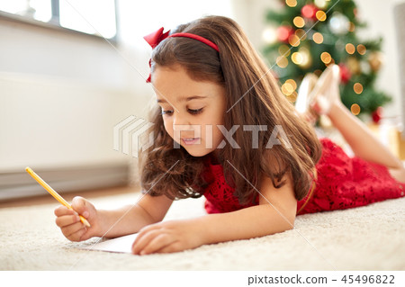 little girl writing christmas wish list at home 45496822