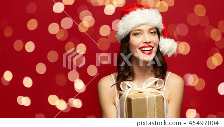woman in santa hat with christmas gift woman in santa hat with christmas gift 45497004