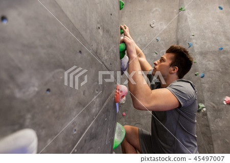 young man exercising at indoor climbing gym 45497007
