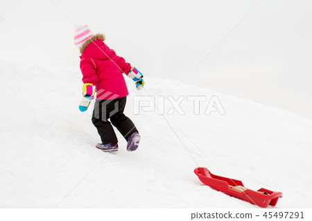 little girl with sled on snow hill in winter 45497291