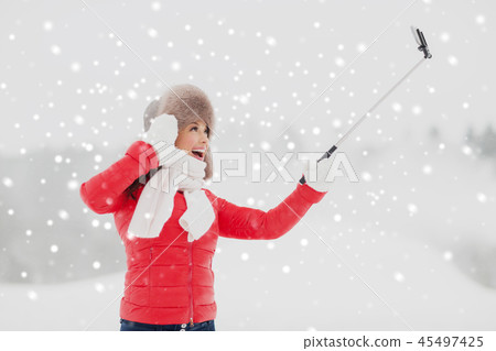 happy woman with selfie stick outdoors in winter happy woman with selfie stick outdoors in winter 45497425