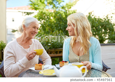daughter with senior mother drinking tea at cafe 45497561